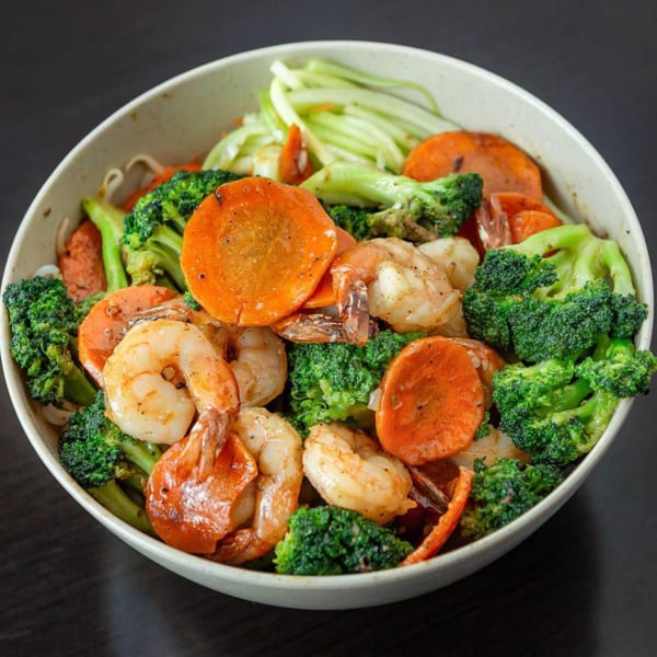 A Vietnamese dish with shrimp, broccoli, and sliced carrots in a white bowl.