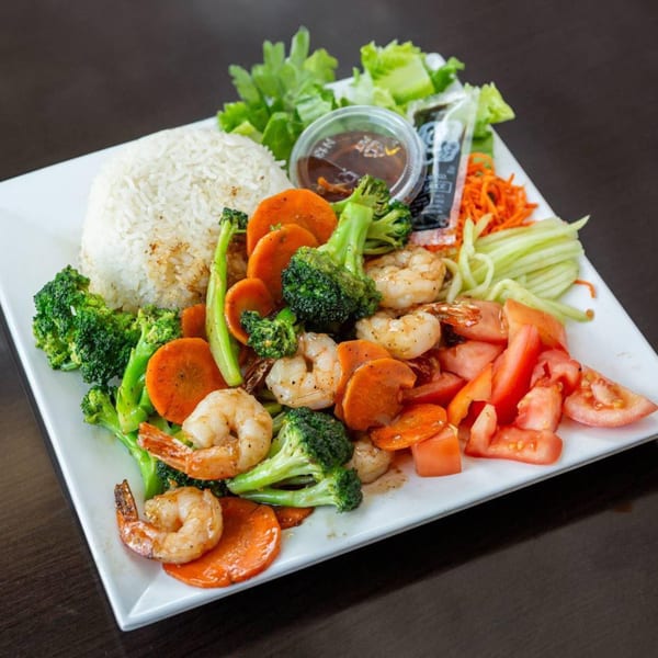 Vietnamese shrimp and vegetable stir-fry with white rice, fresh lettuce, and dipping sauce.